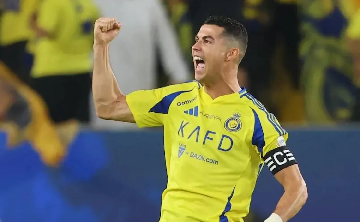 Cristiano Ronaldo celebrating a goal for Al-Nassr, raising his arms in triumph during a Saudi Pro League match.