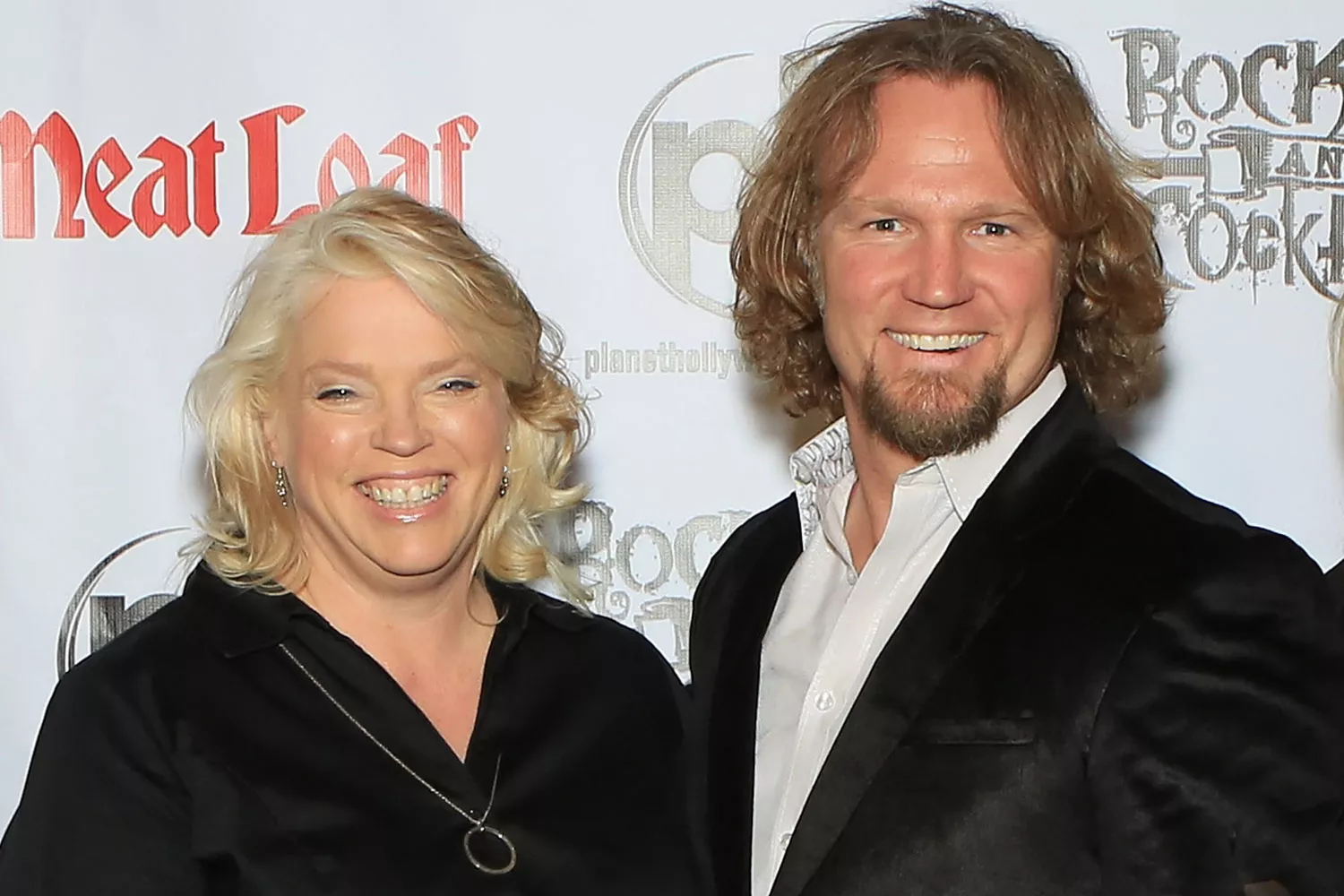 Janelle Brown and Kody Brown posing together on the red carpet at a Sister Wives event, smiling for photographers.
