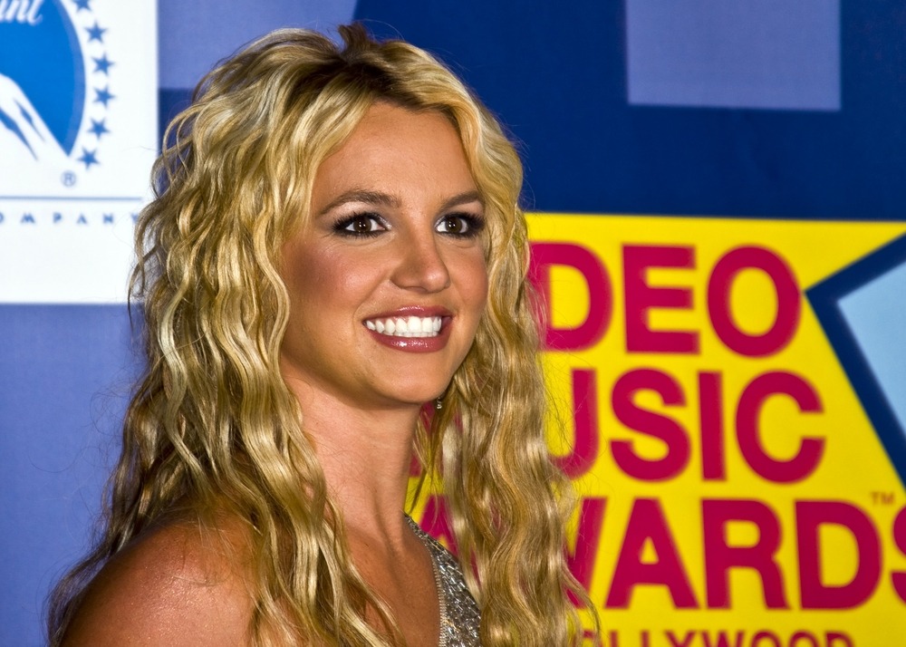 Britney Spears smiling on the red carpet at a public event.