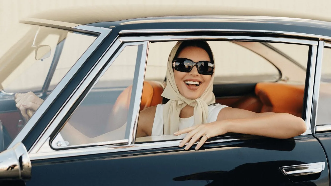 Kendall Jenner in a Fanatics Sportsbook Super Bowl ad, smiling and speaking directly to the camera on set.