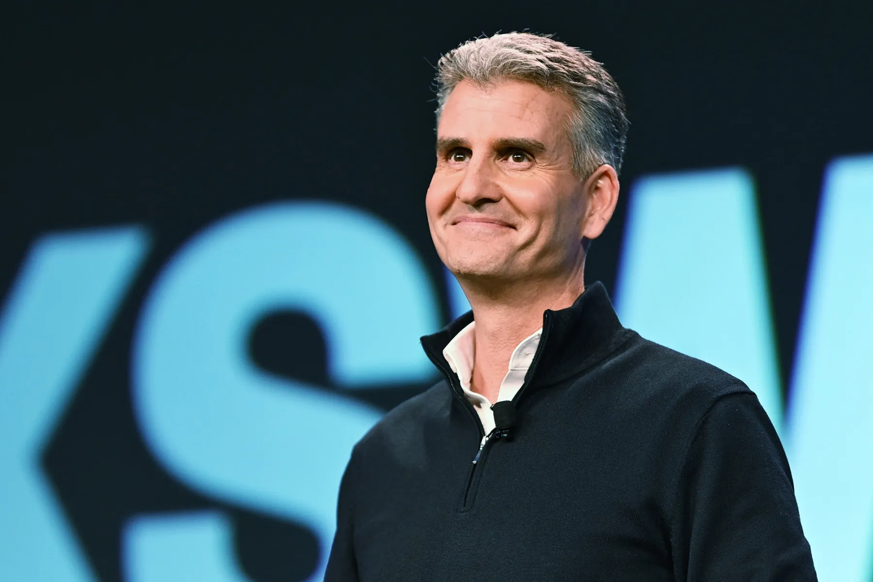 Josh D’Amaro delivering a speech on stage, addressing Disney employees and stakeholders at a corporate event.
