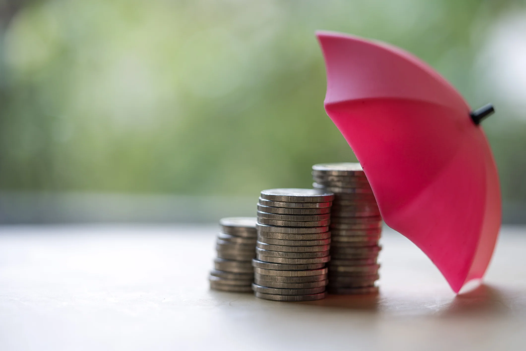 red umbrella and the stack of coins. keeping money safe. savings protection.