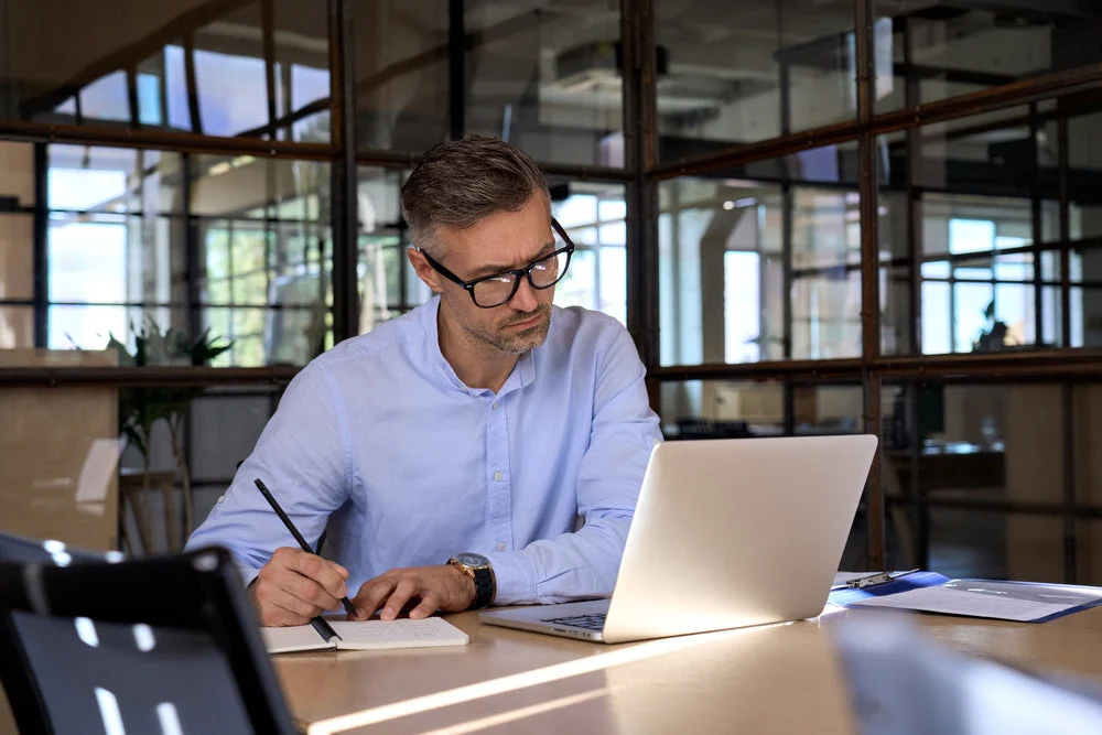Founder-led finance firm principal working alone with financial data screens