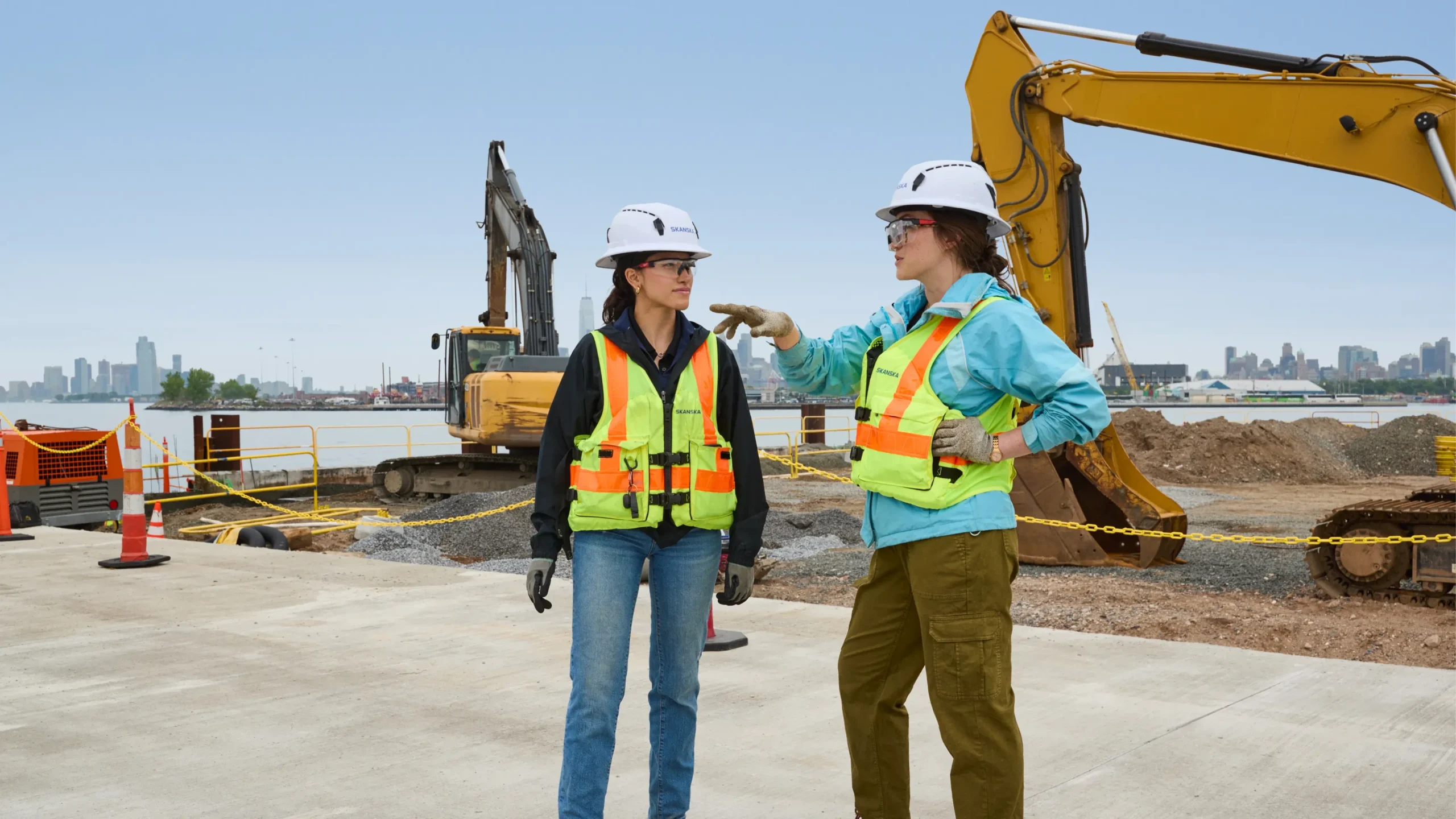 Construction manager reviewing project costs on a tablet at a busy building site