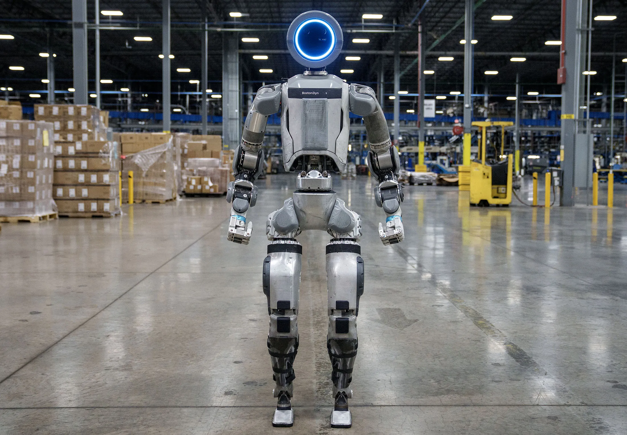 Hyundai Atlas humanoid robot operating on a factory floor alongside machinery