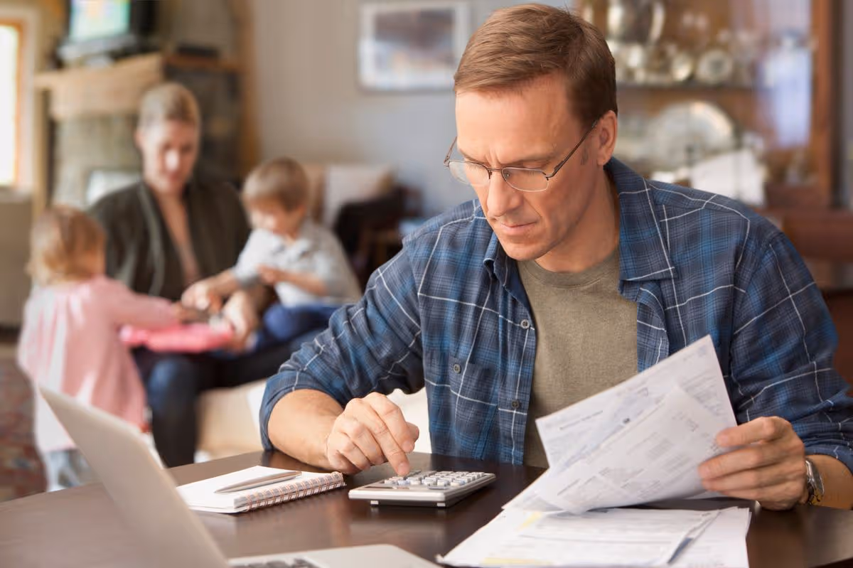 Family reviewing tax documents while managing household expenses.