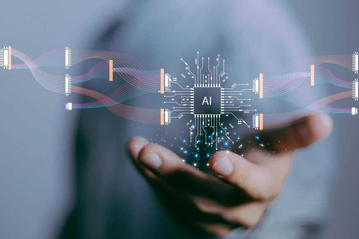 A hand holding a futuristic AI computer chip surrounded by glowing holographic data and digital circuits, symbolizing advanced technology and artificial intelligence.