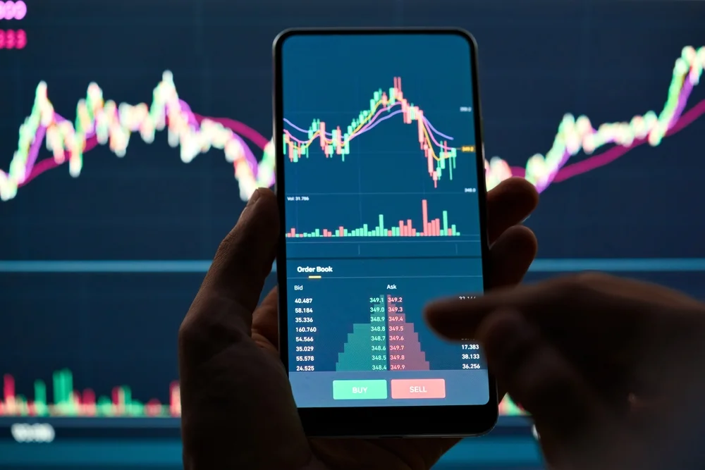 crypto,trader,investor,broker,holding,finger,using,cell,phone,app