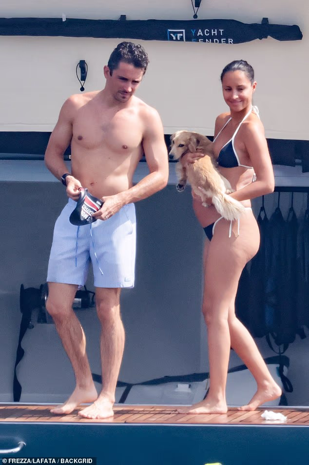 Charles Leclerc's wife Alexandra showed off her 'baby bump' in a black thong bikini as she joined him and their miniature dachshund on a £15million yacht in Sardinia on Wednesday